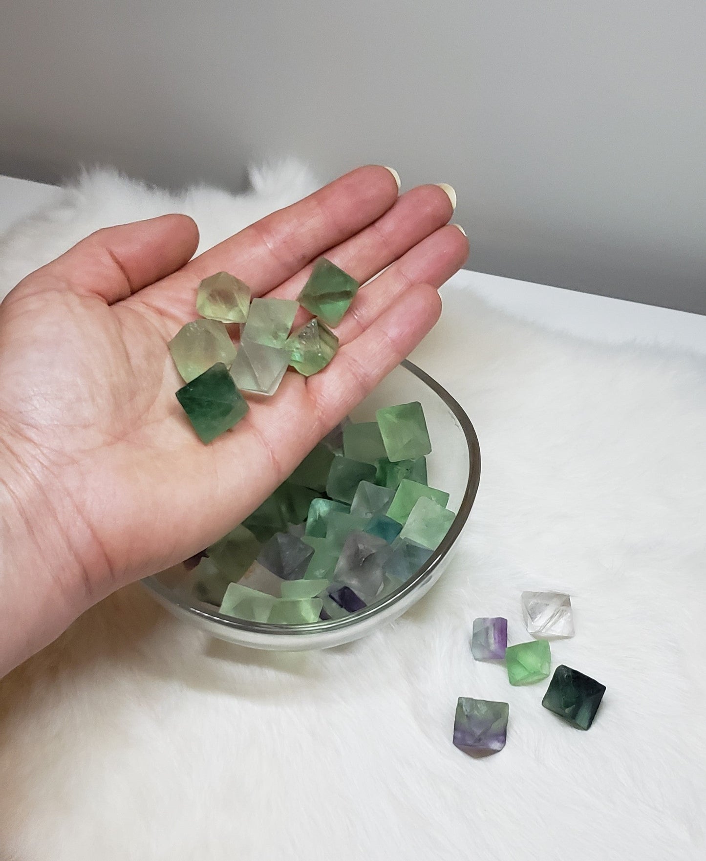 Various sizes of Fluorite crystals in their natural diamond shape in various colours ranging from green, light green, purple, and clear.